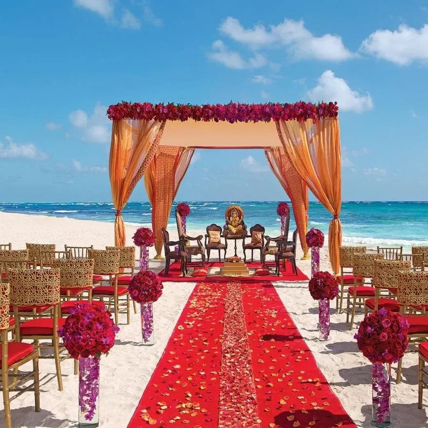 Beach wedding mandap with a red petal aisle